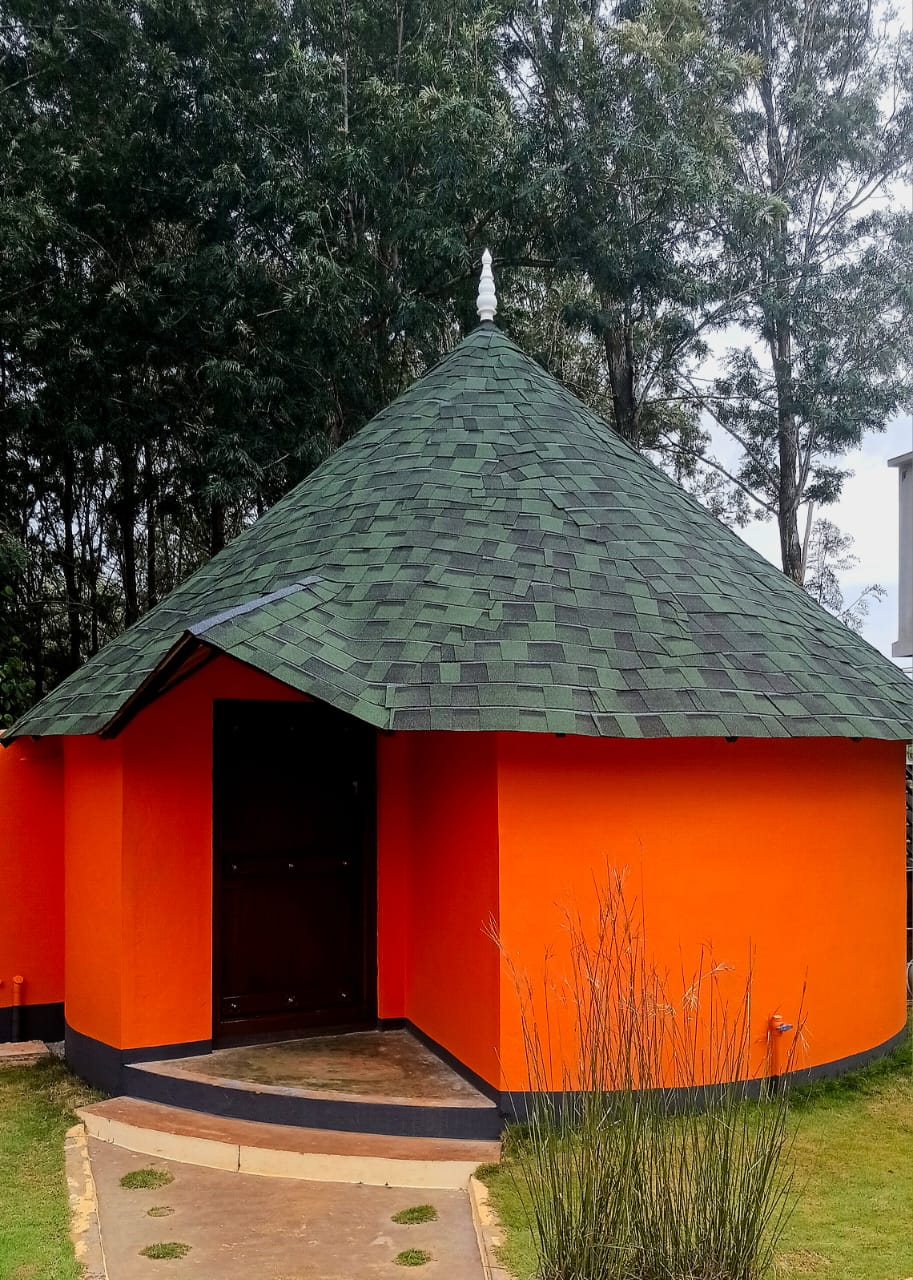 Traditional Kudil cottage surrounded by greenery